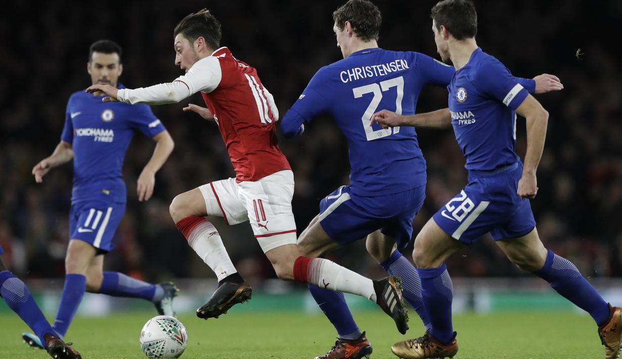 Aksi pemain Arsenal, Mesut Ozil melewati kepungan pemain Chelsea pada laga semifinal Piala Liga Inggirs di Emirates stadium, London, (24/1/2018). Arsenal menang 2-1. (AP/Matt Dunham)