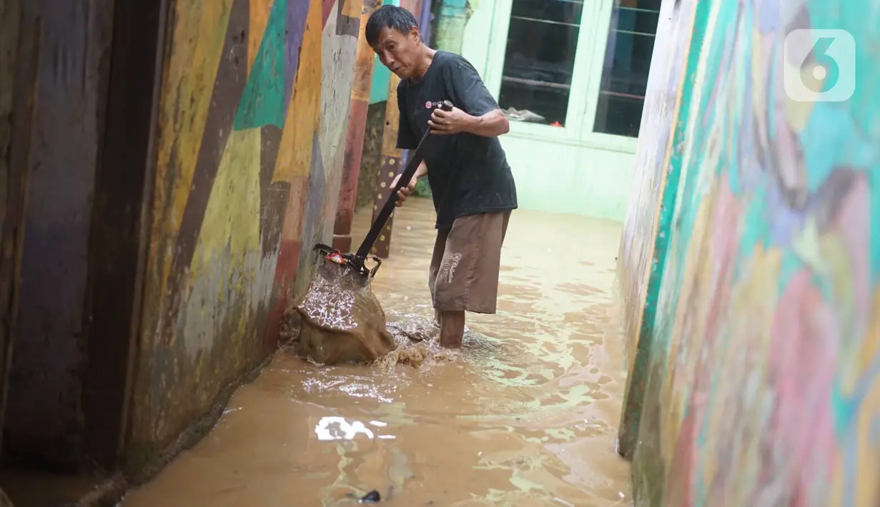 Warga membersihkan banjir yang merendam kawasan Rawajati, Jakarta Selatan, Sabtu (8/2/2020). Hujan yang terjadi semalaman menyebabkan Sungai Ciliwung kembali meluap hingga membuat rumah warga di kawasan tersebut terendam air setinggi 50 cm hingga 1 m. (Liputan6.com/Immanuel Antonius)