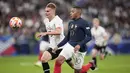 Bek timnas Austria Philipp Lienhart berebut bola dengan penyerang Prancis Kylian Mbappe pada laga lanjutan UEFA Nations League 2022/2023 di Srade de France, Jumat dini hari WIB (23/9/2022). Kylian Mbappe dan Olivier Giroud mencetak masing-masing satu gol untuk membawa Prancis mengalahkan Austria 2-0. (AP Photo/Christophe Ena)