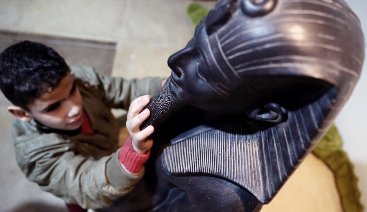 Seorang anak penyandang tunanetra menyentuh sebuah artefak di Museum Mesir di Kairo, Mesir (13/1/2020). Museum ini adalah rumah bagi koleksi antik bangsa Mesir kuno dan memiliki 120.000 koleksi. (Xinhua/Ahmed Gomaa)