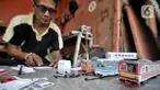 Iskandar (52) saat menyelesaikan pembuatan miniatur kereta api di kawasan Manggarai, Jakarta, Kamis (21/11/2019). Sudah 6 tahun bapak dari 2 anak ini menekuni profesi sebagai pembuat miniatur kereta api berbagai jenis, mulai dari KRL, kereta jarak jauh, hingga MRT. (merdeka.com/Iqbal S. Nugroho)