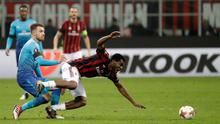 Pemain AC Milan, Franck Kessie tersungkur saat berebut bola dengan pemain Arsenal Aaron Ramsey pada pertandingan Liga Europa leg pertama di stadion San Siro Milan, Italia (8/3). AC Milan takluk 0-2 dari Arsenal. ( AP Photo / Luca Bruno)