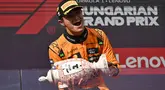 Pembalap McLaren, Lando Norris mengangkat trofi saat merayakan kemenangan dalam ajang balap Formula 1 GP Hungaria 2025 di sirkuit Hongaroring, Minggu (03/08/2025) waktu setempat. (AP Photo/Denes Erdos)
