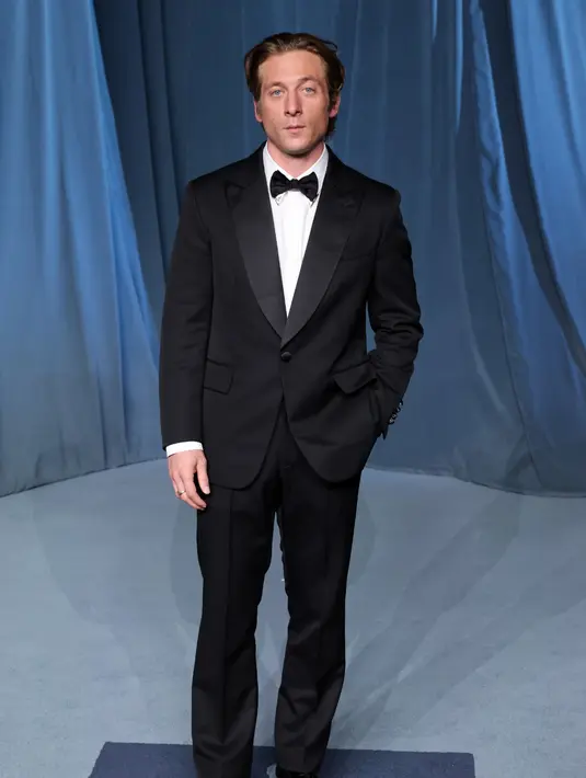 Aktor Jeremy Allen White memilih gaya klasik nan berkelas lewat setelan tuksedo single-breasted peak lapel berwarna hitam, dipadukan dengan kemeja putih berujung kerah perak dan sepatu derby hitam. Ia melengkapi tampilannya dengan jam tangan Tambour berbahan emas kuning, sentuhan sempurna yang mempertegas karismanya di karpet merah. [Dok/Louis Vuitton].