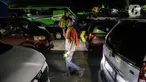Seorang pedagang asongan menjajakan dagangannya di Pelabuhan Merak, Kota Cilegon, Banten, Rabu (19/4/2023). (Liputan6.com/Faizal Fanani)