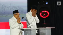 Capres nomor urut 01 Joko Widodo dan Cawapres Ma'ruf Amin saat berdoa pada Debat Pilpres 2019 kelima di Hotel Sultan, Jakarta, Sabtu (13/4). Debat kelima merupakan debat terakhir dalam masa kampanye dan mengambil tema Ekonomi, Kesejahteraan Sosial, Keuangan dan Investasi. (Liputan6.com/Johan Tallo)