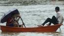 Sejumlah remaja menggunakan kano untuk melewati banjir di Rantau Panjang, timur laut Malaysia, Selasa (3/1). Akibat hujan lebat yang turun terus menerus selama empat hari di Malaysia, 5.000 warga terpaksa dievakuasi. (AFP PHOTO/STR/Malaysia OUT)