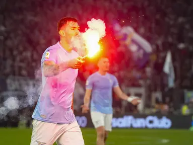 Bek Lazio Alessio Romagnoli memegang flare yang dilemparkan ke lapangan pada laga perempat final Coppa Italia 2023/2024 melawan AS Roma di Stadio Olimpico, Kamis (11/1/2024) dini hari WIB. (AP Photo/Gregorio Borgia)