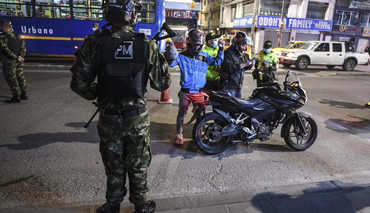 Tentara polisi militer Kolombia memeriksa sepeda motor saat mereka berpatroli di sebuah pos pemeriksaan di Bogota (15/9/2021). Ratusan tentara telah berpatroli di jalan-jalan untuk mengendalikan gelombang perampokan dengan kekerasan. (AFP/Juan Barreto)
