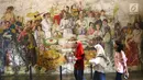Pengunjung melintasi lukisan yang ada di Museum Fatahillah dan Museum Wayang, Kota Tua, Jakarta, Selasa (26/6). Pemprov DKI menggratiskan biaya masuk sejumlah museum menyambut HUT ke-491 Jakarta. (Liputan6.com/Arya Manggala)
