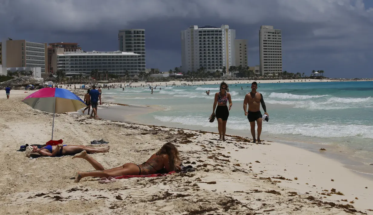 Wisatawan berjemur di pantai sebelum kedatangan Badai Grace, di Cancun, Meksiko, Rabu (18/8/2021). Badai tropis Grace yang menguat menjadi badai pada 18 Agustus 2021 meluncur ke arah pantai Karibia, Meksiko dan mengancam akan membawa hujan lebat, banjir bandang dan gelombang besar. (AP/Marco Ugarte)