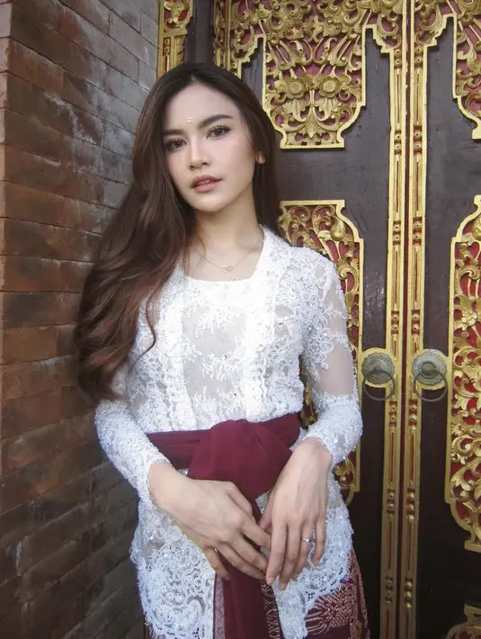 Mahalini tampil mengenakan kebaya putih brokat saat acara adat di Bali. Istri Rizky Febian ini memadukannya dengan belt kain maroon senada dengan kain bawahan khas Bali. [@mahaliniraharja]