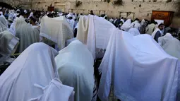 Ribuan umat Yahudi menggelar doa di Tembok Barat Kota Tua Yerusalem, Senin (2/4). Ritual ini berlangsung delapan hari selama libur Paskah. (MENAHEM KAHANA/AFP)