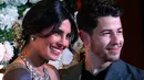 Pasangan Priyanka Chopra dan Jonas berpose untuk resepsi kedua pernikahan mereka di Mumbai, Rabu (19/12). Resepsi ketiga Priyanka Chopra dan Nick Jonas akan diadakan Kamis (20/12) malam dengan mengundang rekan selebritis Bollywood. (AP/Rajanish Kakade)