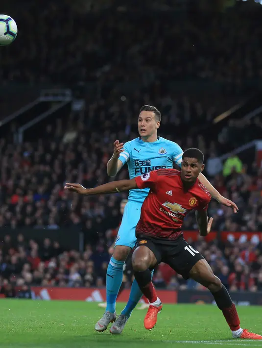 Striker Manchester United, Marcus Rashford berebut bola dengan pemain Newcastle United Javier Manquillo saat bertanding pada lanjutan Liga Inggris di stadion Old Trafford (6/10). MU menang tipis atas Newcastle 3-2. (AP Photo/Jon Super)