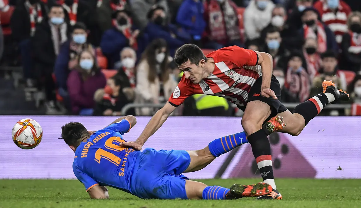 Bek Athletic Bilbao, Daniel Vivian berebut bola dengan penyerang Valencia, Hugo Duro pada pertandingan leg pertama semifinal Copa del Rey di stadion San Mames di Bilbao, Spanyol, Jumat (11/2/2022). Athletic Bilbao bermain imbang atas Valencia 1-1. (AP Photo/Alvaro Barrientos)