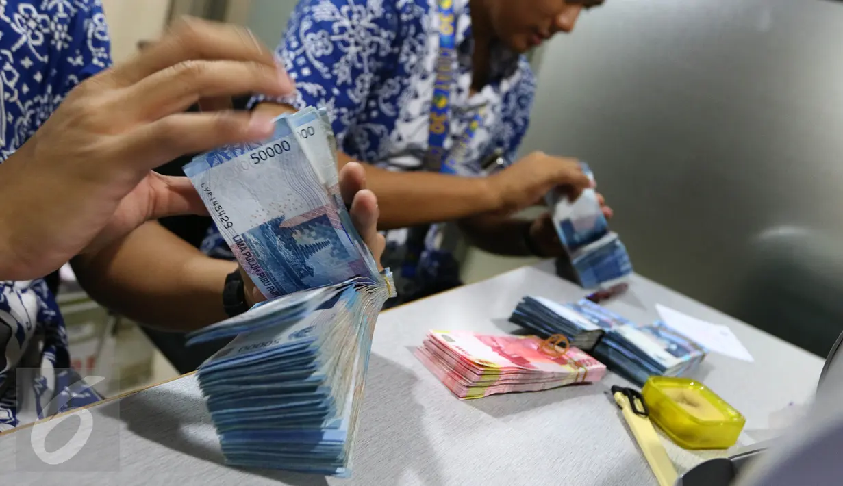 Petugas Bank Indonesia (BI) menghitung uang saat menggelar layanan penukaran uang receh di Lantai 7 SCTV Tower, Jakarta, Jumat (24/6). BI membawa uang Rp 700 juta untuk ditukarkan oleh para karyawan EMTEK Group. (Liputan6.com/Fery Pradolo)