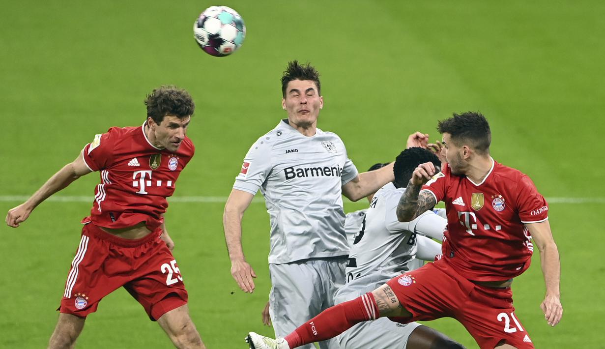 Striker Bayern Munich, Thomas Mueller (kiri) menyundul bola saat menghadapi Bayer Leverkusen dalam laga lanjutan Liga Jerman 2020/2021 pekan ke-30 di Allianz Arena, Munich, Selasa (20/4/2021). Bayern Munich menang 2-0 atas Leverkusen. (AP/Christof Stache/Pool)