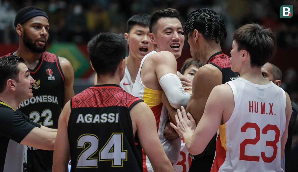 Pemain Timnas Basket China, Zhai Xiaochuan (tengah) tak mau memberikan bola kepada pemain Timnas Basket Indonesia, Derrick Michael Xzavierro (kiri) meski wasit telah meniup peluit saat laga playoff perempat final FIBA Asia Cup 2022 antara Timnas Basket China melawan Timnas Basket Indonesia di Istora Senayan, Jakarta, Senin (18/07/2022). (Bola.com/Bagaskara Lazuardi)