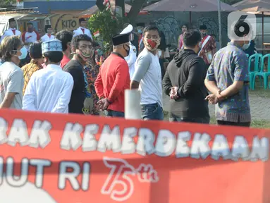 Warga Rt 06 Rw 10 mengikuti upacara HUT ke-75 Kemerdekaan RI di Kelurahan Ciater, Serpong, Tangerang Selatan, Senin (17/8/2020). Selain mengenakan baju adat, tak sedikit warga yang berpakaian seadanya untuk memperingati 17 Agustus dengan tetap menerapkan protokol Kesehatan. (merdeka.com/Dwi Narwoko)