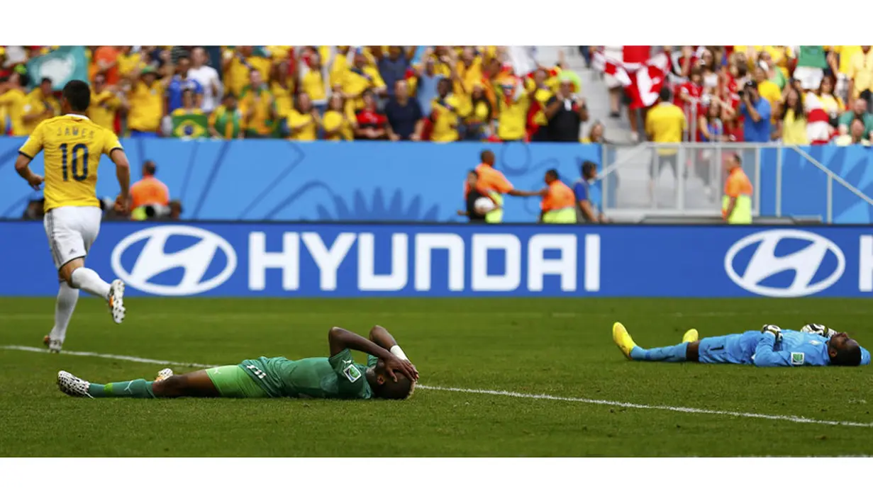 Dua pemain Pantai Gading tergeletak usai gelandang Kolombia, James Rodriguez (10) mencetak gol buat Los Cafeteros di laga penyisihan Piala Dunia 2014 Grup C di Stadion National Mane Garrincha, Brasil, (19/6/2014). (REUTERS/Paul Hanna)