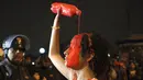 Seorang aktivis pro-aborsi menuangkan cat merah di kepalanya saat melakukan aksi protes di pusat kota Lima, Peru, (12/8/2015). Mereka menuntut pemerintah Peru untuk mengubah Undang-Undang aborsi dalam kasus pemerkosaan. (REUTERS/Guadalupe Pardo)