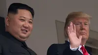 Presiden AS Donald Trump (kanan) melambaikan tangan saat tampil bersama Pemimpin Korea Utara Kim Jong-un di balkon Hotel Capella, Pulau Sentosa, Singapura, Selasa (12/6). Trump dan Kim telah bertemu untuk pertama kalinya. (SAUL LOEB/AFP)