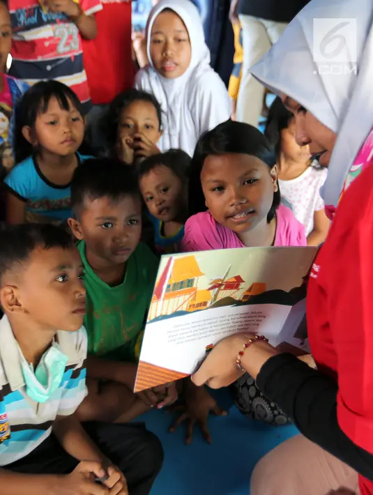 Anak-anak korban gempa tsunami Palu mendengarkan cerita bergambar di halaman kantor Dinas Sosial Palu, Sulawesi Tengah, Sabtu (6/10). Trauma healing juga diberikan agar anak-anak percaya diri dan kembali ceria. (Liputan6.com/Fery Pradolo)