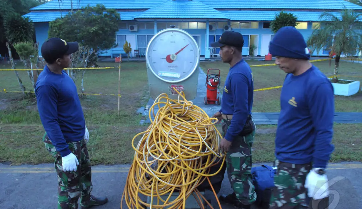 Sejumlah petugas dari penyelam TNI-AL menimbang perlengkapan tambahan yang akan digunakan untuk mengangkat ekor pesawat AirAsia QZ8501 di Lanud Iskandar, Pangkalan Bun, Kalteng, Sabtu (10/1/2015).  (Liputan6.com/Andrian M Tunay)