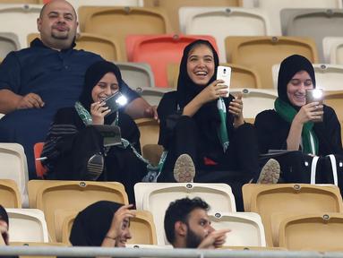 Suporter wanita klub Al-Ahli asal Arab Saudi antusias menyaksikan laga timnya melawan Al-Batin pada Saudi Pro League di King Abdullah Sports City, Jeddah, (12/1/2018). Arab Saudi untuk pertama kalinya mengizinkan wanita menonton di stadion. (AFP/STRINGER)