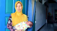 Jabang bayi yang lahir di lantai teras rumahnya ini dalam kondisi sehat dalam dekapan neneknya (Liputan6.com/Yuliardi Hardjo)