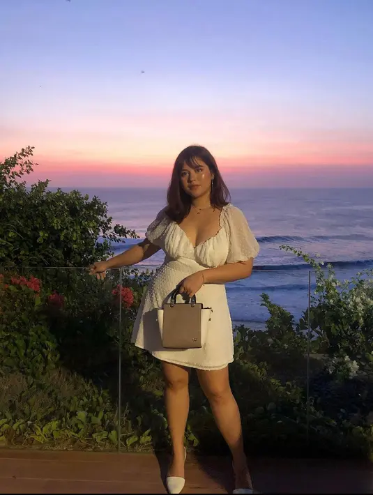 Menikmati senja di pantai dengan dress warna putih berbahan katun paris yang di bordir dengan detail bentol bentol akan membuatmu tampil menawan. (instagram/sarahayu_)