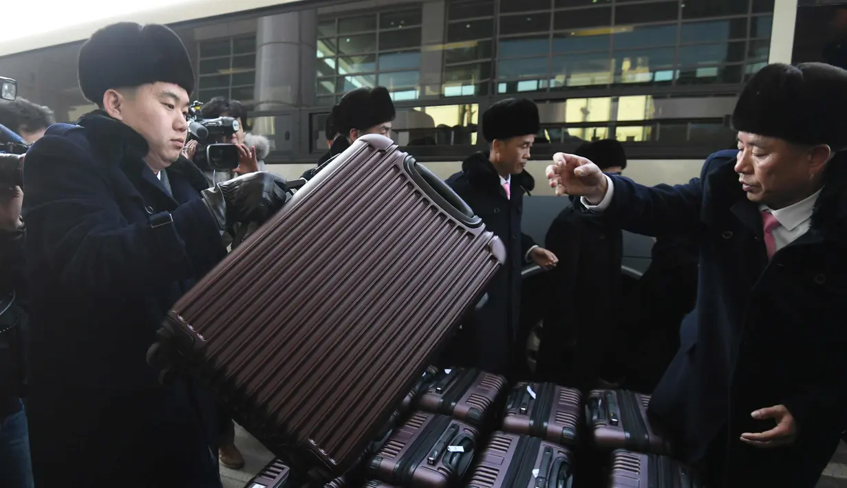 Rombongan grup orkestra Korut merapihkan koper saat tiba di kantor transit Korea di DMZ di Paju (5/2). Korut mengirim rombongan seni Samjiyon beranggota 140 orang ke Selatan untuk dua konser di ibukota Seoul dan di Gangneung. (AFP Photo/Pool/Jung Yeon-Je)