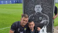 Seorang bobotoh asal Aceh, Khairil Fikri, memberikan lukisan kepada pemain dan pelatih Persib Bandung di Lapangan Pendamping Stadion Gelora Bandung Lautan Api, Bandung, Jumat (30/10/2026). (Bola.com/M. Faqih)