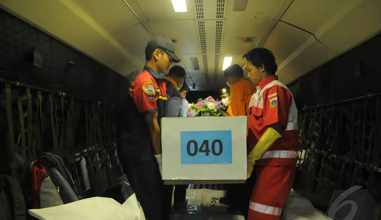 Tim SAR gabungan saat mengangkat jenazah korban pesawat AirAsia QZ8501 untuk dikeluarkan dari pesawat CN-295 di Lanud Juanda, Surabaya, Kamis (8/1/2015). (Liputan6.com/Herman Zakharia)