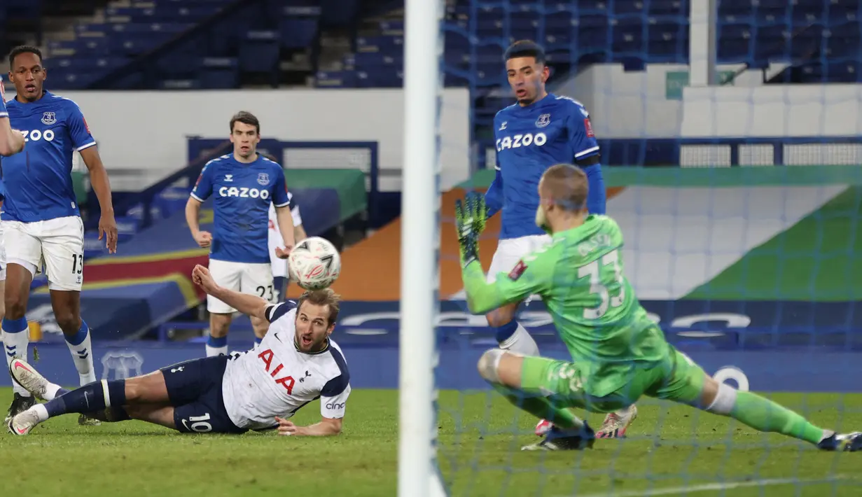 Striker Tottenham Hotspur, Harry Kane (tengah) melepaskan tendangan yang mampu dimentahkan kiper Everton, Robin Olsen dalam laga babak kelima Piala FA 2020/21 di Goodison Park, Rabu (10/2/2021). Tottenham kalah 4-5 (4-4) dari Everton melalui extra time. (AFP/Clive Brunskill/Pool)