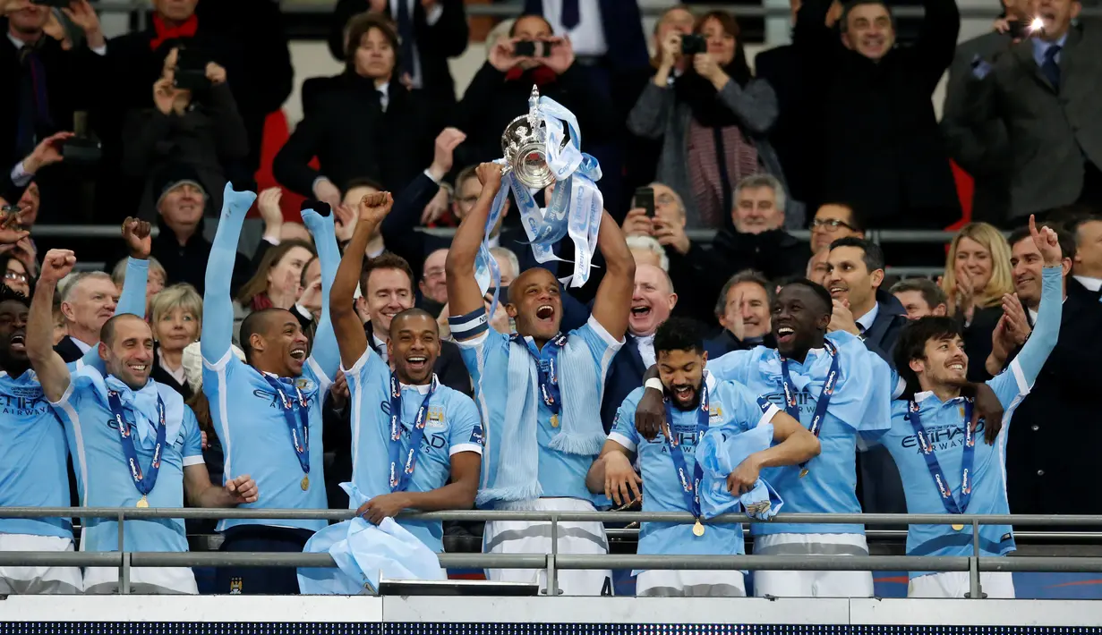 Kapten Manchester City, Vincent Kompany, mengangkat trofi juara Piala Liga Inggris setelah mengalahkan Liverpool di final Piala Liga Inggris di Stadion Wembley, London, Senin (29/2/2016) dini hari WIB. (Action Images via Reuters/Paul Childs)