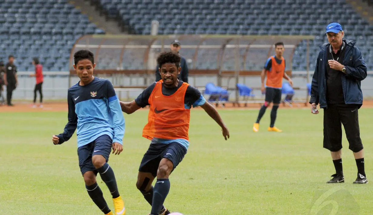 Pelatih timnas Indonesia, Alfred Riedl (kanan) memperhatikan pergerakan Evan Dimas (kiri) dan Imanuel Wanggai saat berlatih di Stadion GBK Jakarta, Kamis (13/11/2014). (Liputan6.com/Helmi Fithriansyah)