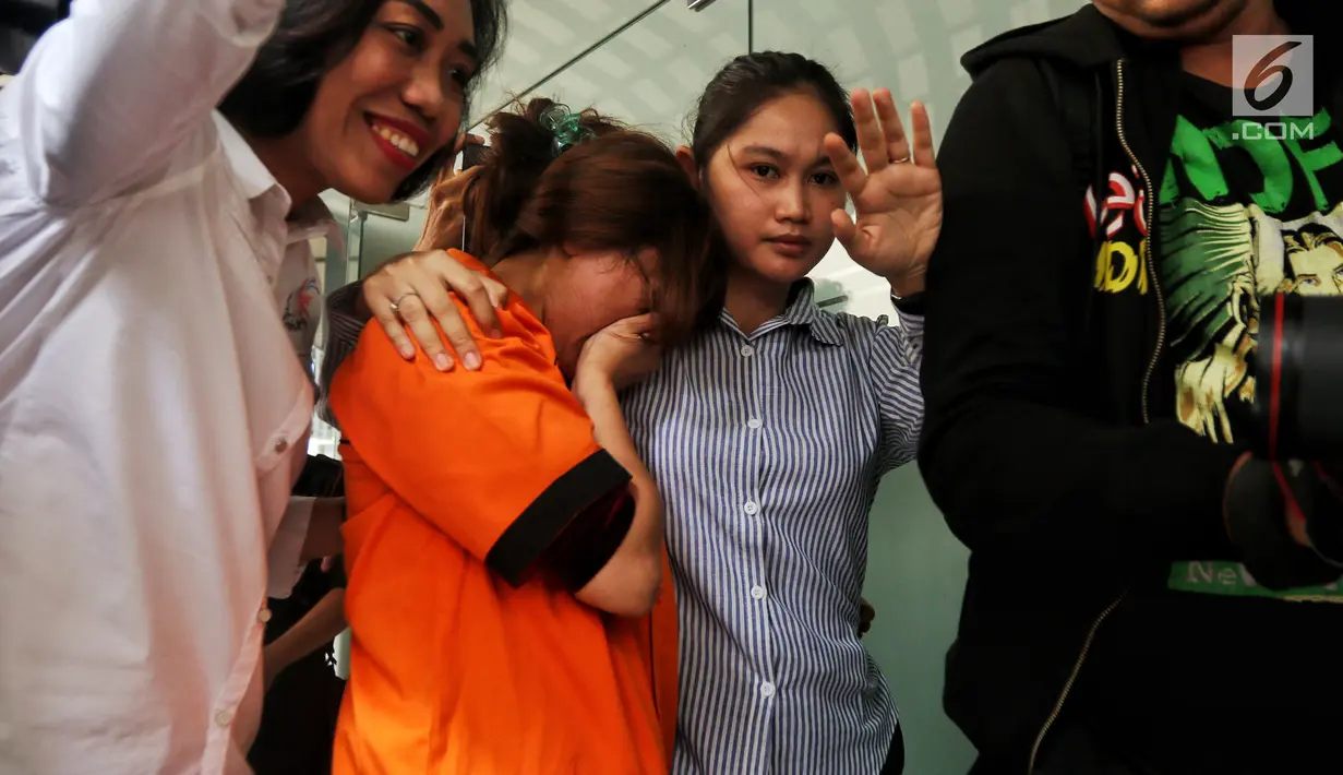 Artis Cahya Wulan Sari alias Chacha, personel Duo Molek menutupi wajahnya usai jumpa pers di Direktorat Narkoba Polda Metro Jaya, Jakarta, Senin (14/1). Chacha diringkus di kamar Apartemen Batavia, Jakarta Selatan. (Liputan6.com/Johan Tallo)