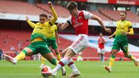 Bek Arsenal, Kieran Tierney, berebut bola dengan bek Norwich City, Max Aarons, pada laga lanjutan Premier League pekan ke-32 di Emirates Stadium, Kamis (2/7/2020) dini hari WIB. Arsenal menang 4-0 atas Norwich City. (AFP/Mike Egerton/pool)