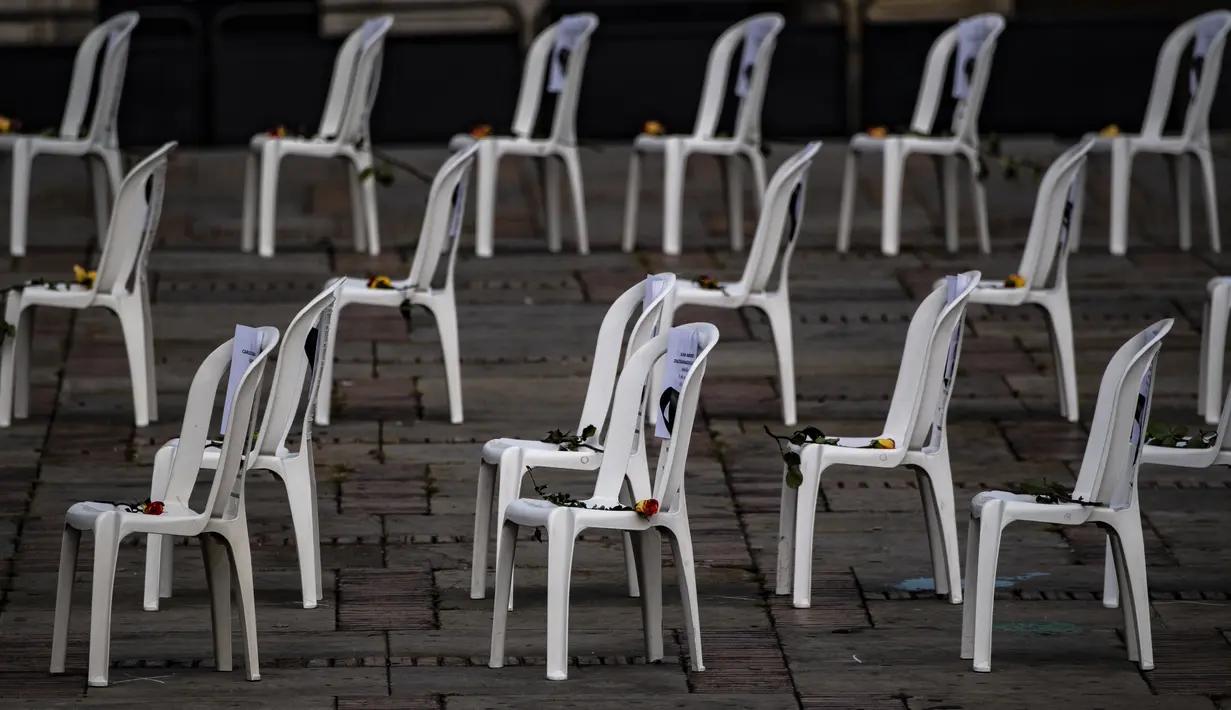 Bangku dengan nama petugas kesehatan yang meninggal karena COVID-19, pita hitam dan bunga, selama aksi protes terhadap sistem kesehatan di Bogota, Senin (26/10/2020). Kolombia pada Sabtu, 24 Oktober, melampaui satu juta kasus COVID-19 yang dikonfirmasi sejak dimulainya pandemi. (Juan BARRETO/AFP)