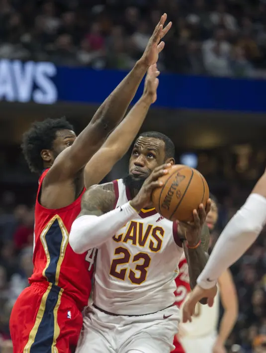 Pebasket Cleveland Cavaliers, LeBron James, berusaha melewati pebasket New Orleans Pelicans,Solomon Hill, pada laga NBA di Quicken Loans Arena, Sabtu (31/3/2018). Cavaliers menang 107-102 atas Pelicans. (AP/Phil Long)