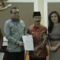 Menpan RB Syafruddin (kedua kiri) dan Bupati Kabupaten Solok Selatan Muzni Zakaria (kedua kanan) menunjukkan berkas CPNS dokter gigi Romi Syofpa Ismael di kantor Kemenpan RB, Jakarta, Senin (5/8/2019). (Liputan6.com/Angga Yuniar)