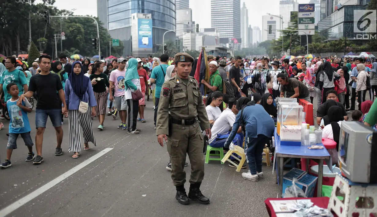 Satpol PP DKI Jakarta menertibkan PKL yang berdagang di kawasan Car Free Day, Bundaran HI, Jakarta, Minggu (20/1). Penertiban dilakukan karena telah membuat ketidaknyamanan bagi para pengunjung CFD yang ingin berolahraga. (Liputan6.com/Faizal Fanani)