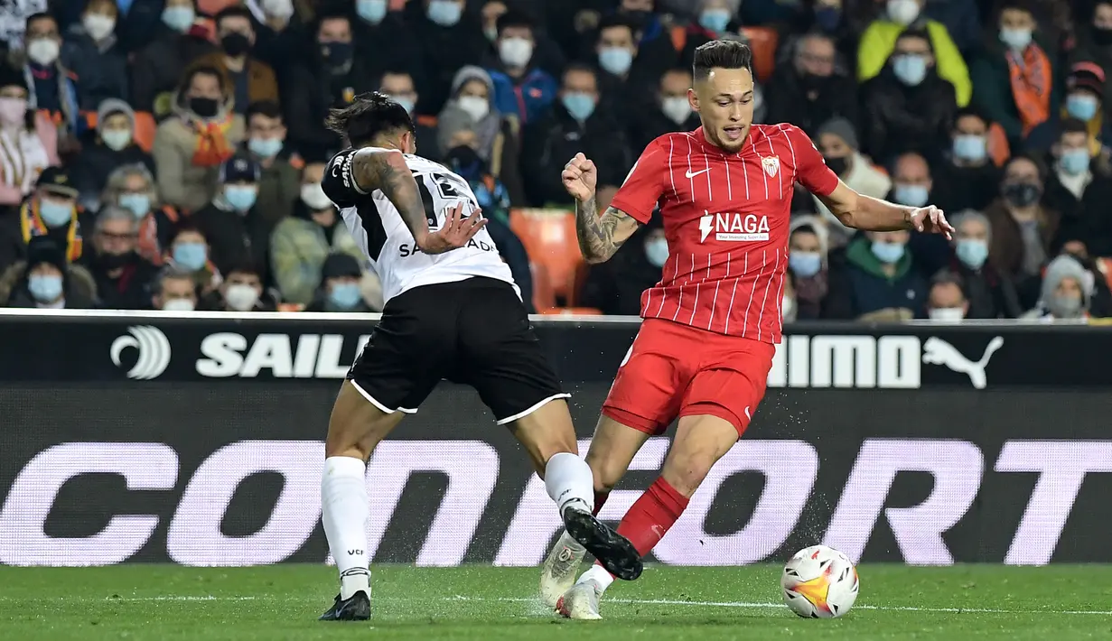 Bek Valencia, Omar Alderete (kiri) berusaha merebut bola dari gelandang Sevilla, Lucas Ocampos pada pertandingan lanjutan La Liga Spanyol di stadion Mestalla di Valencia (20/1/2022).  Hasil imbang ini membuat Valencia naik ke posisi sembilan karena sudah mengumpulkan 29 poin. (AFP/Jose Jordan)