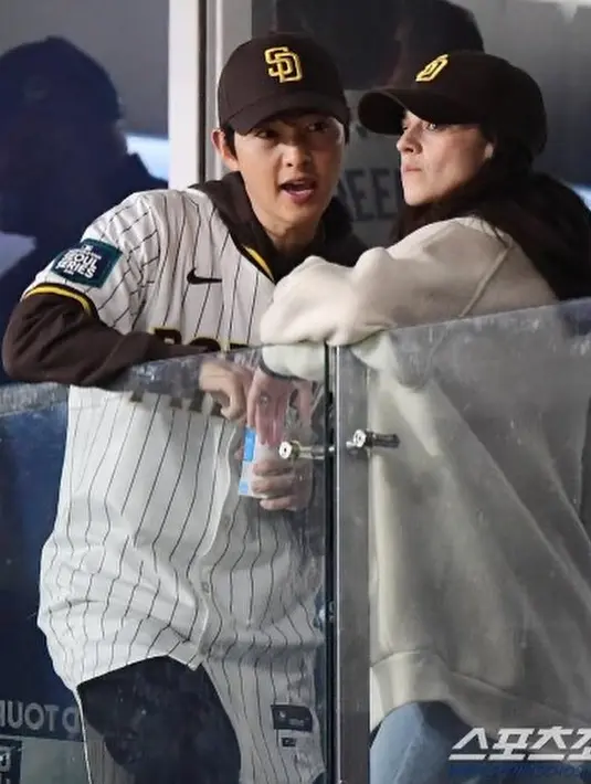 Sedangkan Katy Louise tampil mengenakan hoodie hitam yang ditumpuknya dengan outer cokelat. Keduanya juga tampak kompak mengenakan topi hitam yang sama. [Foto: Instagram/thesongjoongki]