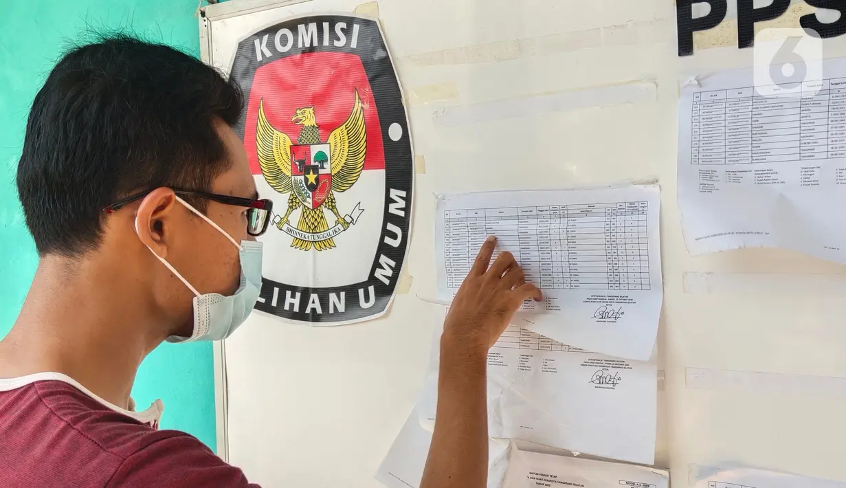 Warga mengecek Daftar Pemilih Tetap (DPT) di kelurahan Parigi, Tangerang, Selasa (8/12/2020). Pengecekan untuk memastikan agar warga dapat mengikuti pemilihan kepala daerah yang akan berlangsung besok. (Liputan6.com/Angga Yuniar)