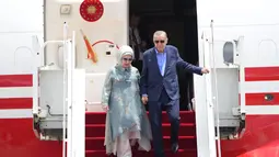 Presiden Turki Recep Tayyip Erdogan didampingi istrinya Emine turun dari pesawat setibanya di Bandara Internasional Ngurah Rai menjelang KTT G20 di Bali, Indonesia, Senin (14/11/2022). Erdogan tetap berangkat ke Indonesia meski ada insiden ledakan yang sebelumnya terjadi di Istanbul. (AP Photo/Firdia Lisnawati )