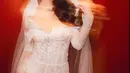 Ia nampak kenakan busana pengantin berupa jumpsuit pendek brukat dengan lengan off shoulder. Lapisan lace dari pinggang jadi siluet rok slit yang elegan [@eri.carl]