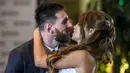 Bintang Barcelona, Lionel Messi, mencium bibir sang istri, Antonella Roccuzzo, dihadapan wartawan usai mengadakan resepsi pernikahan di Kompleks City Center, Santa Fe, Jumat (30/6/2017). (AFP/Eitan Abramovich)